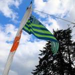 A 12 flag flutters in the breeze from a canoe mast, on the lawn outside the House of Awakened Culture, July 20, during the 2017 Canoe Journey. Canoe families are traveling to We Wei Kai and Wei Wai Kum First Nations territory at Campbell River, B.C. (Richard Walker/Kitsap News Group)