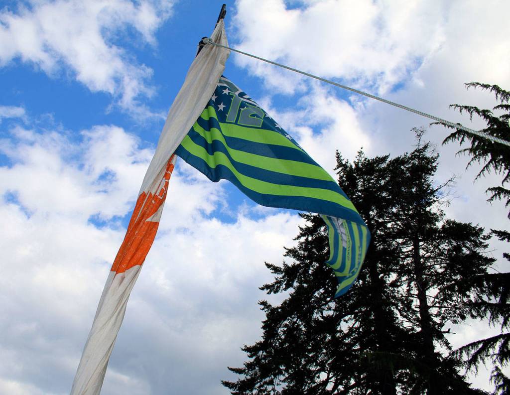 A 12 flag flutters in the breeze from a canoe mast, on the lawn outside the House of Awakened Culture, July 20, during the 2017 Canoe Journey. Canoe families are traveling to We Wei Kai and Wei Wai Kum First Nations territory at Campbell River, B.C. (Richard Walker/Kitsap News Group)