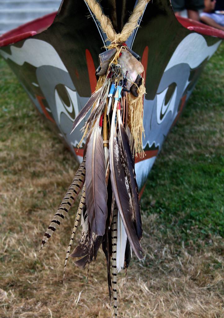 Eagle feathers are among those that adorn the bow of this Coast Salish canoe, on the lawn outside the House of Awakened Culture, July 20, during the 2017 Canoe Journey. Canoe families are traveling to We Wei Kai and Wei Wai Kum First Nations territory at Campbell River, B.C. (Richard Walker/Kitsap News Group)