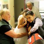 Six-year-old Clarence Ulrich and his older sister, Evelyn, hug Diesel while Watland (at left) and the children&rsquo;s great-grandmother watch. It was Evelyn&rsquo;s birthday and Integrative Health Practitioner Evelyn Enns (not pictured) gave both children an official Diesel trading card.                                Terryl Asla/Kitsap News Group