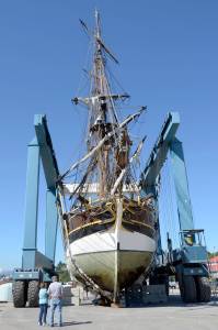 Pat and Jim Hay of Port Townsend stand in front of the Lady Washington, which was hauled out of the water in Port Townsend to inspect the hull for damage after the ship ran aground in Sequim Bay on Monday. (Cydney McFarland/Peninsula Daily News) ​