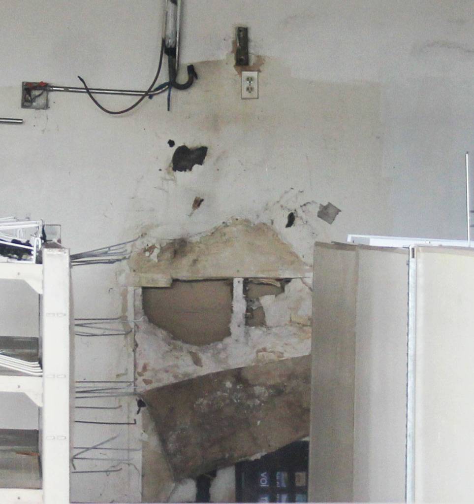 From the sidewalk outside, mold-damaged drywall and an exposed electrical wire are clearly visible. (Richard Walker/Kitsap News Group)