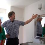 Scott Studerus, with wife Kim looking on, shows their handiwork remodeling the small home&rsquo;s bathroom. Photo: Bob Smith | Kitsap Daily News