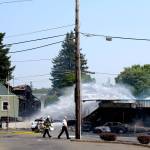 Crews from the Bremerton, South Kitsap, Central Kitsap and Navy Region Northwest fire departments work together to put out a two-alarm fire that started in Motor City Automotive, at the corner of North Callow Avenue and 11th Street, around 12:16 p.m. Aug. 3.                                Michelle Beahm / Kitsap News Group