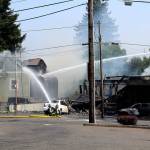Crews from the Bremerton, South Kitsap, Central Kitsap and Navy Region Northwest fire departments work together to put out a two-alarm fire that started in Motor City Automotive, at the corner of North Callow Avenue and 11th Street, around 12:16 p.m. Aug. 3.                                Michelle Beahm / Kitsap News Group