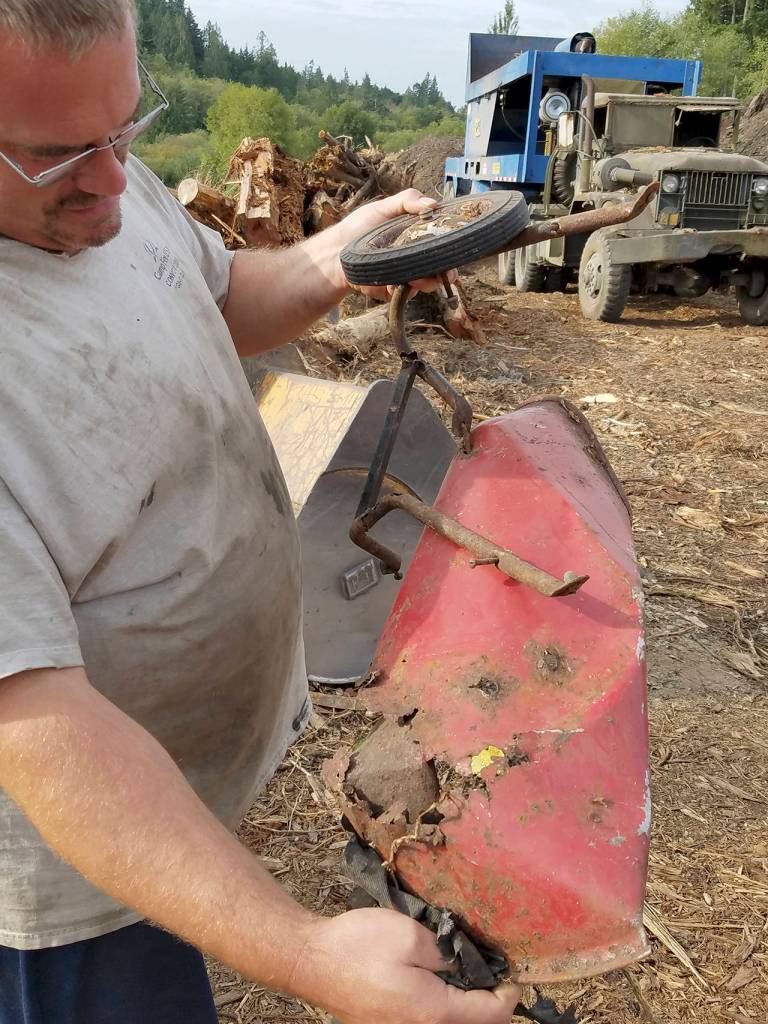 Scrap materials, such as concrete chunks, bricks and even this mangled metal toy wheelbarrow, are separated from the wood before it is ground.                                Terryl Asla/Kitsap News Group