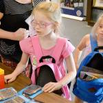 Kailey, 7, of Silverdale, looks over the items on the table during Operation Homefront&rsquo;s annual Back-to-School Brigade. (Mark Krulish/Kitsap News Group)