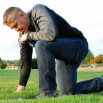 Former Bremerton High School football coach Joe Kennedy kneels on the 50-yard line of a football field in prayer in this photo provided in June by First Liberty Institute.