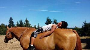Devon Tom, Port Gamble S&rsquo;Klallam, relaxes with Joey, a stallion, at Lynne Ferguson&rsquo;s Native Horsemanship Youth Program. (Courtesy photo)