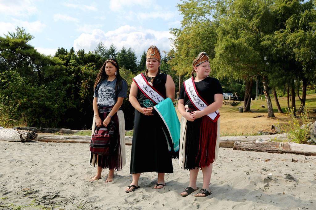 Young women await the arrival of a canoe, from left, 2017-18 Miss Chief Seattle Days Katelynn Pratt, 2016-17 Miss Chief Seattle Days Hailey Crow, 2016-17 Jr. Miss Chief Seattle Days Mackenzie Crow. (Antonia Stoyanovich photo)