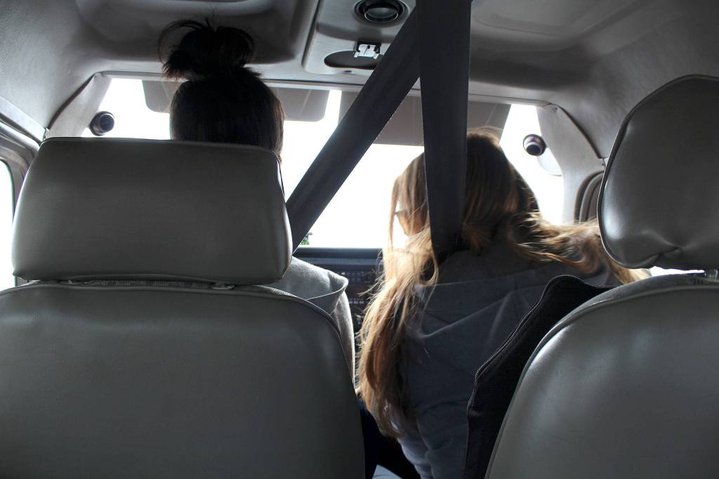 Mary Suligoy, at right, instructs Mikela Arnall, 14, how to take off while piloting a small plane.                                Michelle Beahm / Kitsap News Group