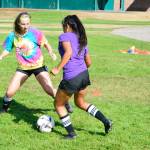 Mark Krulish | Independent                                Senior midfielder Savannah Foster look to take the ball from her teammate during defensive drills at summer practice.