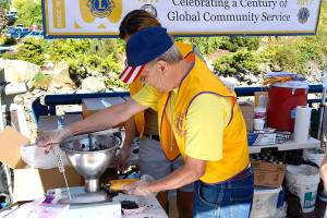 Jim Lamb, president of the Bremerton Central Lions Club, inserts blackberry filling to create the famed treat known as a &ldquo;slug.&rdquo; (Mark Krulish/Kitsap News Group)