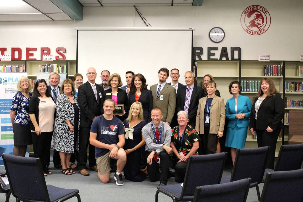 The Washington Business Alliance, administrators from the Central Kitsap School District, Sen. Christine Rolfes, D-23rd District, and Rolfes&rsquo; team gather in the Ridgetop Middle School Library, where Rolfes accepted an award from the WBA after they group toured the school&rsquo;s aviation classroom.                                Michelle Beahm / Kitsap News Group