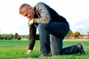 Joe Kennedy kneels on the 50-yard line of a football field in prayer in a photograph provided the Liberty Institute. Kennedy and his lawyers filed a petition Sept. 21 requesting that his case be considered by the entire circuit court &mdash; 11 judges, including the chief judge.