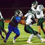 Olympic senior Mason Quitevis (14) pulls down Port Angeles running back Jake Allen (29) behind the line of scrimmage during the Trojans&rsquo; 59-13 win on Senior Night.