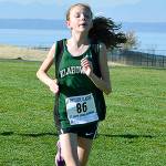 Left, Rachel Newhard leads the pack at Chambers Bay on Oct. 28. She captured Klahowya&rsquo;s first individual district championship in over a decade. Right, Lucas Becker crosses the finish line in fourth place at the West Central District meet.                                Mark Krulish/Kitsap News Group