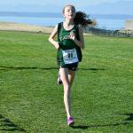 Left, Rachel Newhard leads the pack at Chambers Bay on Oct. 28. She captured Klahowya&rsquo;s first individual district championship in over a decade. Right, Lucas Becker crosses the finish line in fourth place at the West Central District meet.                                Mark Krulish/Kitsap News Group