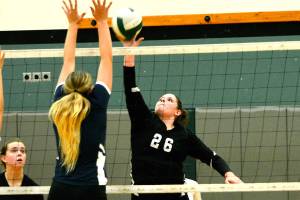 Klahowya&rsquo;s Chloe Settle looks to tip a ball past the Cascade Christian blockers during their district match on Nov. 2. (Mark Krulish/Kitsap News Group)