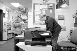 Bonnie Chrey helps a library patron check out a book from the Tracyton Library. Anyone can use the independent library.                                Leslie Kelly | Kitsap Daily News