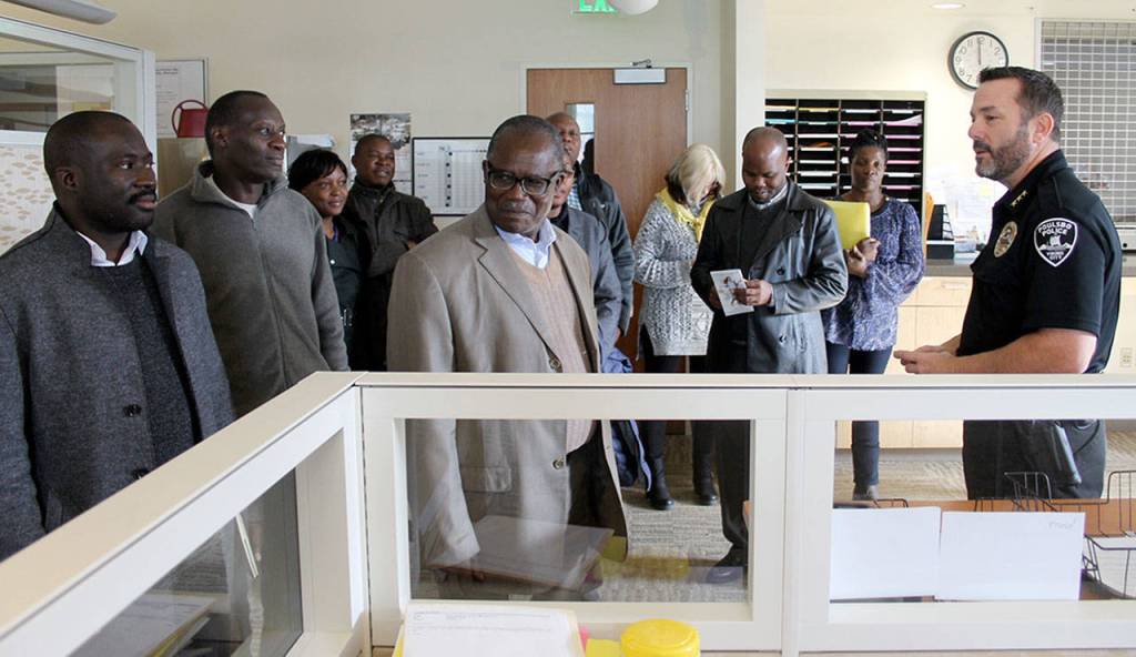 Poulsbo Police Chief Daniel Schoonmaker gives Ugandan officials a tour of the Poulsbo Police Station at City Hall, Nov. 10. Ugandan officials visited City Hall as part of a regional tour to develop political and trade relationships. (Richard Walker/Kitsap News Group)