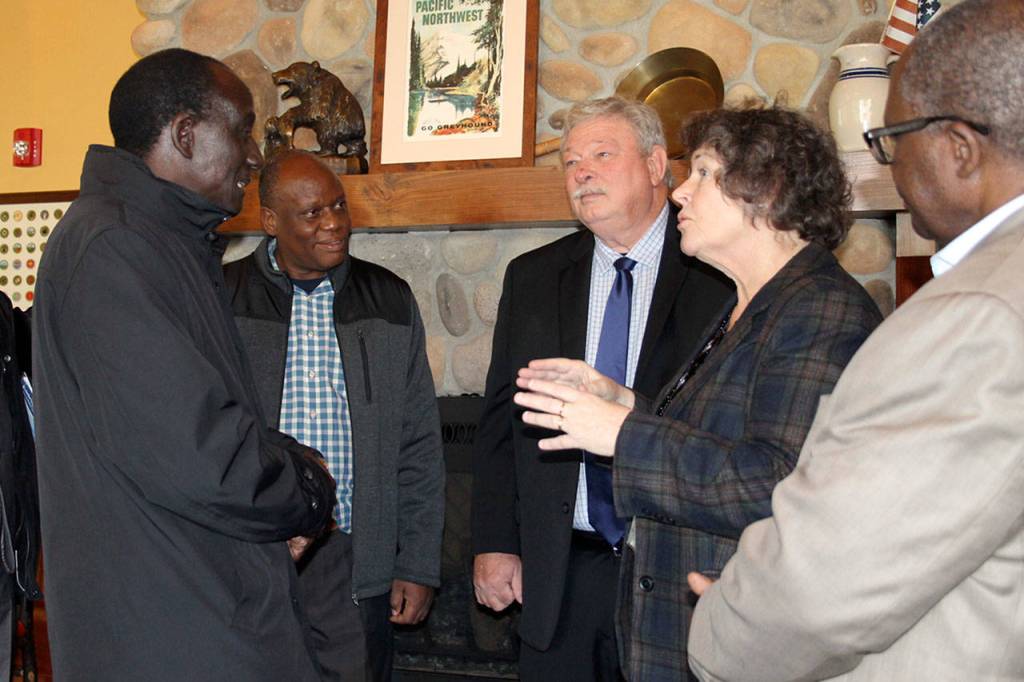 Mayor Becky Erickson greets Ugandan Ambassador to the United States Mull S. Katende, Nov. 10 in the Elmers restaurant banquet room. Katende and other Ugandan officials visited Poulsbo as part of a regional tour to develop political and trade relationships. (Richard Walker/Kitsap News Group)