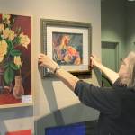 Lone Hansen straightens PAL fellow members hangings at Central Markets upstairs cafe.