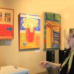 Lone Hansen checks her own paintings hanging at Central Markets upstairs cafe.