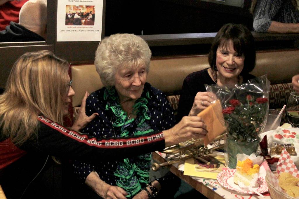 Yvonne McAllister reads a birthday message during her 96th birthday celebration at Casa Mexico in Keyport. (Nick Twietmeyer/Kitsap News Group)