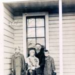 Jorgen Eliason sits on the porch of his home with grandchildren George, William and Edwin. Photo courtesy of the Poulsbo Historical Society.
