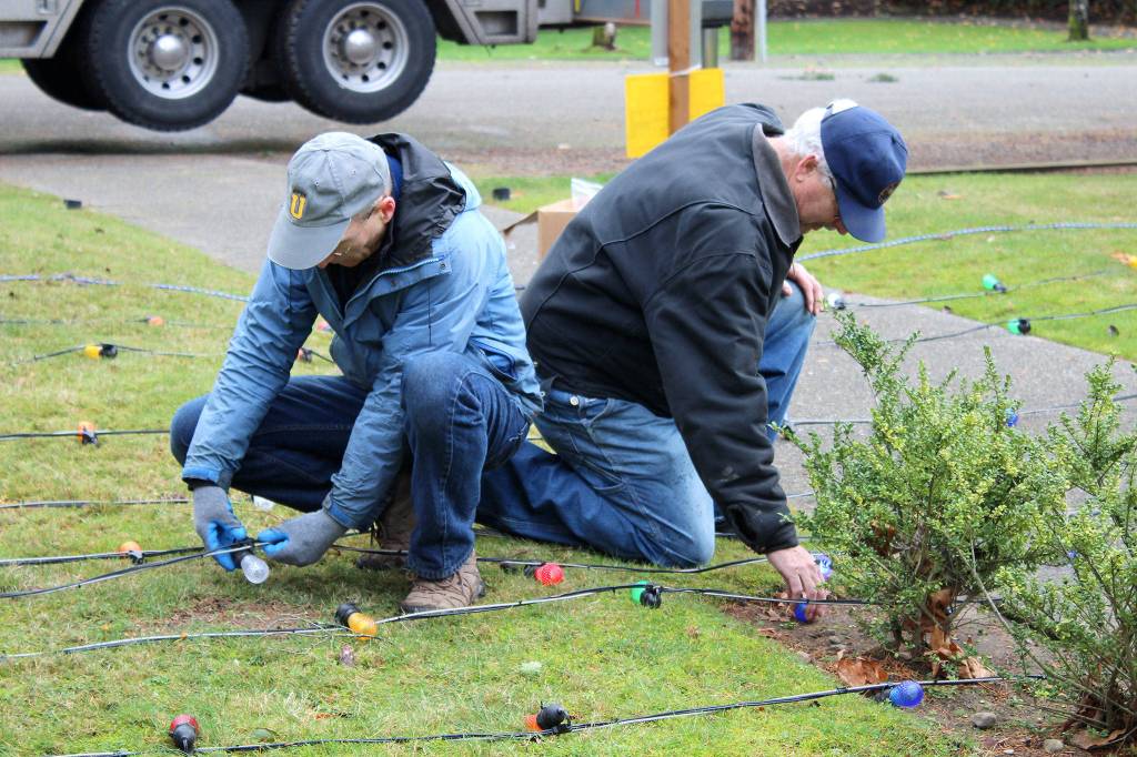 Kurt Tufford, left, and Bob Carter check the lightbulbs before theyre strung on the Tracyton Community Christmas Tree.                                Michelle Beahm / Kitsap News Group