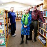 Volunteer Carol Campbell (left), Friends of the Manchester Library Director John Winslow and the organizations president, Ralph Nelson, are longtime champions of the library. Librarian Susan Lavin stands in the foreground. (Photo: Bob Smith | Kitsap Daily News)