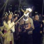 The Lucia Bride, Kaitlyn Bell, prepares to lower her torch onto the Julefest bonfire, Dec. 2 at Muriel Iverson Williams Waterfront Park. (Richard Walker/Kitsap News Group)