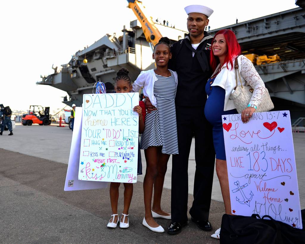 U.S. Navy Aviation Maintenance Administrationman 1st Class Corey Oliver, of Houston, Texas, meets with his family on the pier after the aircraft carrier USS Nimitz (CVN 68), arrived at Naval Air Station North Island, Dec. 5 in Coronado, California. The Nimitz Carrier Strike Group is on a regularly scheduled deployment to the Western Pacific. The U.S. Navy has patrolled the Indo-Asia-Pacific region routinely for more than 70 years promoting peace and security. (Mass Communication Specialist 3rd Class Cole Schroeder/U.S. Navy)