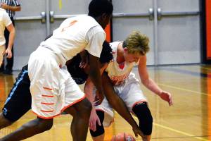 Central Kitsaps Zion Archer and Colby White battle Gig Harbors Malik Livingston for a loose ball in a Dec. 8 league contest. The Tides won 58-54. (Mark Krulish/Kitsap News Group)