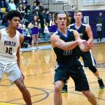 <em>Olympics Evan Turnquist dishes off to a teammate as North Kitsaps Kai Warren (left) steps up to play defense.</em>                                Mark Krulish/Kitsap News Group