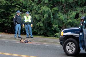 Troopers consult at the site where a woman was struck by a car, Dec. 15 in the crosswalk at Front Street and Torval Canyon Road. (Richard Walker/Kitsap News Group)