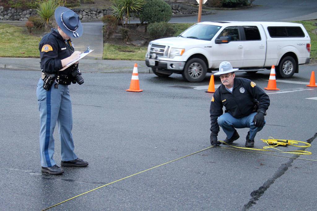 Washington State Patrol troopers collect evidence at the site where a woman was struck by a car, Dec. 15 in the crosswalk at Front Street and Torval Canyon Road. (Richard Walker/Kitsap News Group)