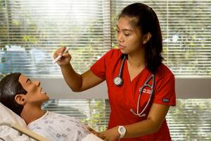 Nursing student Juvylyn Purificacion uses a medical mannequin to practice her assessment skills in Olympic Colleges nursing simulation lab. (Contributed photo)
