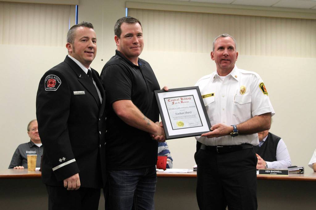 Nathan Sharp receives a Citizen Life-Saving Aard from CKFR Lt. Kevin Bernt, left, and Chief Scott Weninger.                                Gretchen Ta receives a Citizen Life-Saving Award from CKFR Lt. Kevin Bernt, left, and Chief Scott Weninger.                                Michelle Beahm / Kitsap News Group
