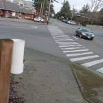 At 7:30 a.m. Jan. 15, crosswalk signage near the crosswalk at the intersection of 8th Avenue and Iverson Street was not visible to motorists because it was on its side and chained to a bolt in the ground. On one side of the street, a holder for pedestrian flags was empty. (Richard Walker/Kitsap News Group)