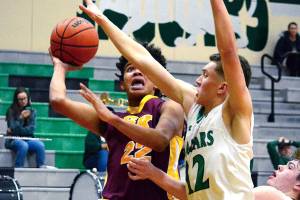 DeAnte Ward (22) drives the lane against the Emerald Ridge defense. Ward scored 23 points, but South Kitsap lost 58-54.                                 Mark Krulish                                Kitsap News Group