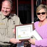 Kitsap County Sheriffs Undersheriff John Gese presents Bill and Susie Slankard with a KCSO Commendation award. (Michelle Beahm | Kitsap Daily News)