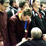 Kingston swimmer Ethan Fox receives a medal from head coach Mark VanHuis after he and his fellow teammates set a new state record in the 200-yard medley relay. (Mark Krulish/Kitsap News Group)