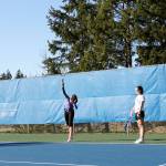 Junior Sydney Troy, right, watches as senior Brooklyn Haro serves the ball in a March 6 practice at the Olympic High School tennis courts. Haro and Troy went to state last year as a doubles team. Jacob Moore | Kitsap News Group