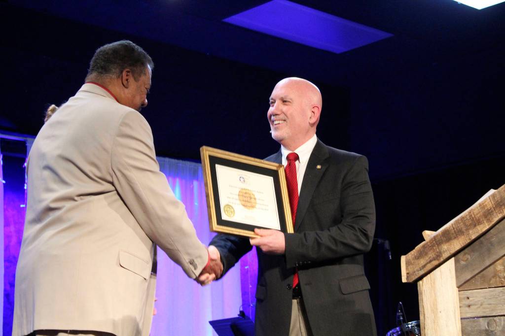 Retired Air Force Col. Steven Wexler presents Robert and Carolynn Perkins with a replica of the Congressional Gold Medal, awarded to Robert Perkins father posthumously.                                Michelle Beahm | Kitsap News Group