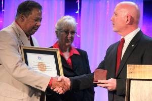 <em>Robert and Carolynn Perkins accept a replica of the Congressional Gold Medal on behalf of Roberts father, Roscoe Perkins.</em>                                Michelle Beahm/Kitsap News Group