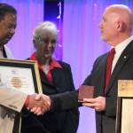 <em>Robert and Carolynn Perkins accept a replica of the Congressional Gold Medal on behalf of Roberts father, Roscoe Perkins.</em>                                Michelle Beahm/Kitsap News Group                                Robert Perkins accepts the congratulations of friends and family after accepting the Congressional Gold Medal on behalf of his late father, Roscoe C. Perkins.                                Michelle Beahm | Kitsap News Group