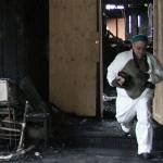 Walter Peale, walks out of what remains of his mothers house, carrying some personal belongings. Jacob Moore | Kitsap News Group