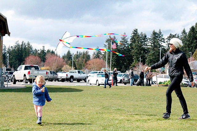 Helena Ptaszynski, 2, runs to get her kite airborne while mother, Beth, coaches nearby. Nick Twietmeyer | Kitsap News Group